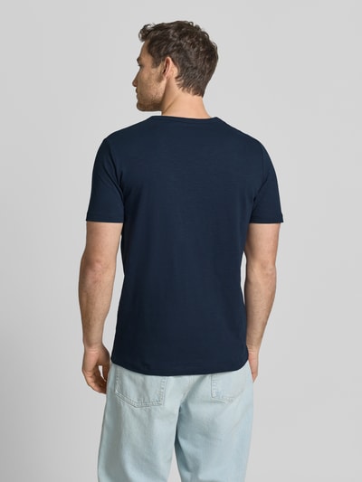 Męski model nosi Regular Fit T-Shirt aus reiner Baumwolle von s.Oliver RED LABEL, efekt: jednolity kolor, krój regular fit, nadruk z motywem, z krótkim rękawem, bawełna, całkowity widok z tyłu.