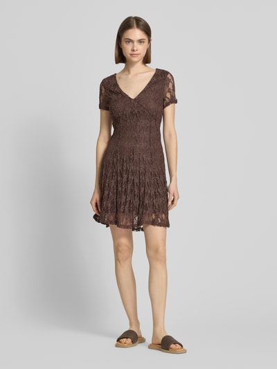 Frauenmodel trägt Slim Fit Minikleid aus Spitze Modell 'ALBINA' von Only, unifarben, Spitzenmuster, V-Ausschnitt, Ganzkörperansicht von vorne.