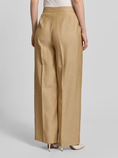 Frauenmodel trägt Wide Fit Stoffhose mit Lyocell-Anteil von Comma in Beige, Material-Mix, Bundfalten, Eingrifftaschen, Ganzkörperansicht Rückansicht.