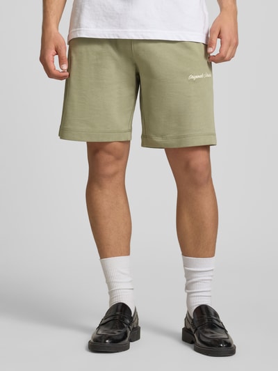 Männermodel trägt Shorts mit Label-Stitching Modell 'KARL' von Jack & Jones, Baumwoll-Mix, Relaxed-Fit, seitliche Eingrifftaschen, Ganzkörperansicht von vorne.