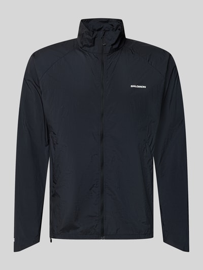 Produktfoto, Jacke mit Stehkragen und Logo von Salomon in Schwarz, glatte Struktur, Reißverschluss, Regular Fit, schlichtes Design