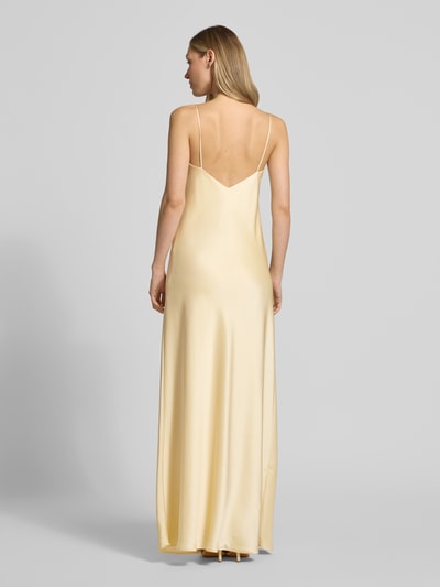 Modelka nosi 'Abendkleid aus Satin mit Spaghettiträgern' od Jake*s Cocktail, żółta satyna, prosty krój, długa sukienka, dekolt w serek, cienkie ramiączka, długość tyłu w rozmiarze 36: 136 cm, szerokość w rozmiarze 36: 43 cm, widok całej sylwetki od tyłu.