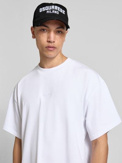 Männermodel trägt Base Cap mit Logo-Stitching von Dsquared2, schwarze Baumwolle, gebogener Schirm, Statement-Stitching, Nahaufnahme Oberkörper.