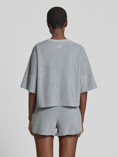 Frauenmodel trägt Relaxed Fit T-Shirt in Bouclé-Optik von Drykorn, reine Baumwolle, grau, strukturierte Oberfläche, Ganzkörperansicht Rückansicht.
