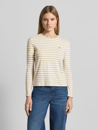 Frauenmodel trägt Longsleeve mit Label-Stitching von Gant, creme-beige gestreift, Reine Baumwolle, Regular-Fit, Rundhalsausschnitt, Rückenlänge 54 cm, Ganzkörperansicht von vorne.