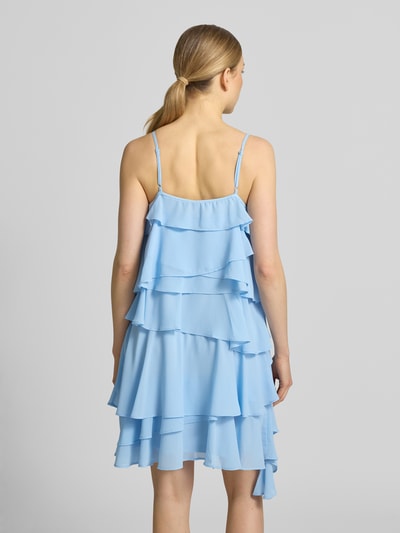 Frauenmodel trägt fließendes Cocktailkleid mit Volants Modell 'ALADYN' von Vero Moda, Optik: Unifarben, Mini-Länge, Ganzkörperansicht Rückansicht.