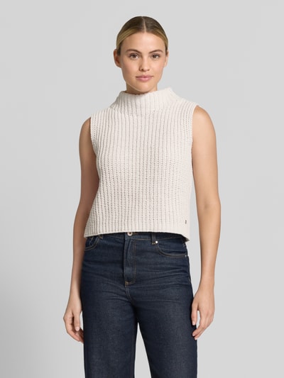 Frauenmodel trägt Regular Fit Top in Strick-Optik von monari, cremefarben, Stehkragen, ärmellos, Rückenlänge 51 cm, Ganzkörperansicht von vorne.