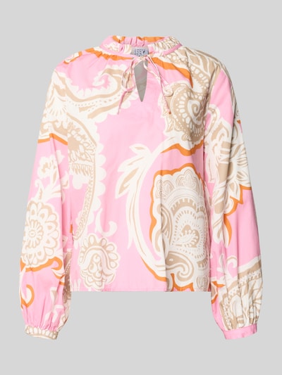 Frauenmodel trägt Regular Fit Bluse mit Allover-Paisley-Print von Emily Van den Bergh, bawełna, stójka z obszyciem falbanami, z długim rękawem, wycięcie w kształcie łezki, zakończenia rękawów, różowo-beżowo-pomarańczowy wzór paisley, długość tyłu w rozmiarze 36: 52 cm, długość rękawa w rozmiarze 36: 60 cm, Ganzkörperansicht von vorne