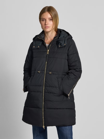 Frauenmodel trägt Regular Fit Mantel mit Logo-Detail von Liu Jo, schwarze Stepp-Optik, Kapuze, Reißverschluss, Ganzkörperansicht von vorne. Damen Mantel, Taschen, Maße: Rückenlänge 93 cm, Schulterbreite 41 cm, Brustweite 55 cm, Ärmellänge 63 cm.
