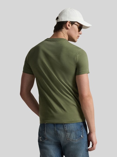Männermodel trägt Regular Fit T-Shirt aus reiner Baumwolle von Polo Ralph Lauren in Oliv, unifarben, mit Logo-Stitching, Ganzkörperansicht Rückansicht.