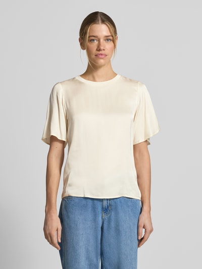 Modelka kobieca ma na sobie T-Shirt aus Viskose-Mix mit Rundhalsausschnitt od comma, kremowy kolor, prosty krój, krótki rękaw, długość tyłu 55 cm, całkowity widok z przodu.