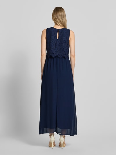 Frauenmodel trägt Maxikleid mit rückseitigem Schlüsselloch-Ausschnitt von Vila aus dunkelblauem Baumwoll-Mix, Gerader-Schnitt, Spitze, Ganzkörperansicht Rückansicht.