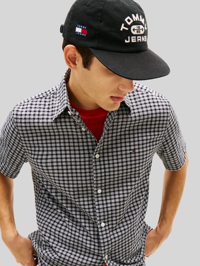 Männermodel trägt Regular Fit Freizeithemd aus Baumwoll-Mix von Tommy Jeans mit Optik:Allover-Muster, gestreift, Logo-Stitching, Crêpe, Nahaufnahme Oberkörper.