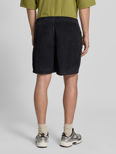 Männermodel trägt Shorts mit elastischem Bund Modell 'PADOW' von American Vintage aus Reine Baumwolle, Loose-Fit, dunkle Farbe, Ganzkörperansicht Rückansicht.