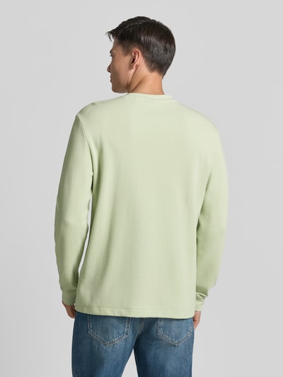 Männermodel trägt Regular Fit Langarmshirt aus Baumwoll-Mix Modell 'WE-TEMPEST' von BOSS Orange in Unifarben, Ganzkörperansicht Rückansicht.