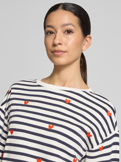 Frauenmodel trägt Sweatshirt im Allover-Look von Smith and Soul, gestreift mit roten Herzen, Rundhalsausschnitt, Nahaufnahme Oberkörper.