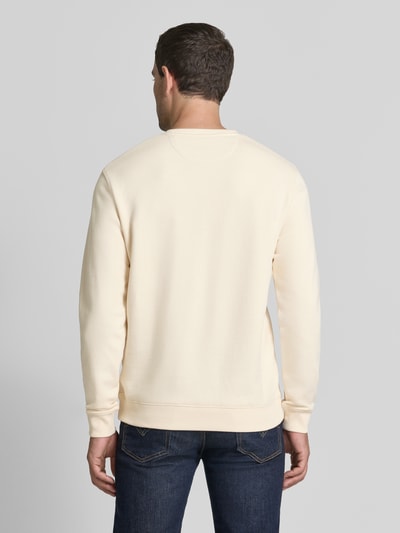 Männermodel trägt Sweatshirt mit Label-Badge und Rundhalsausschnitt van Scotch & Soda in licht crème, puur katoen, regular fit, ruglengte maat M 71 cm, mouwlengte maat M 68 cm, ganzkörperansicht rückansicht