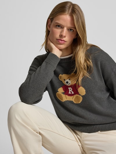 Frauenmodel trägt Strickpullover aus reiner Baumwolle von REVIEW, dunkelgrau mit Bärenmotiv, lockere Passform, Nahaufnahme Oberkörper.