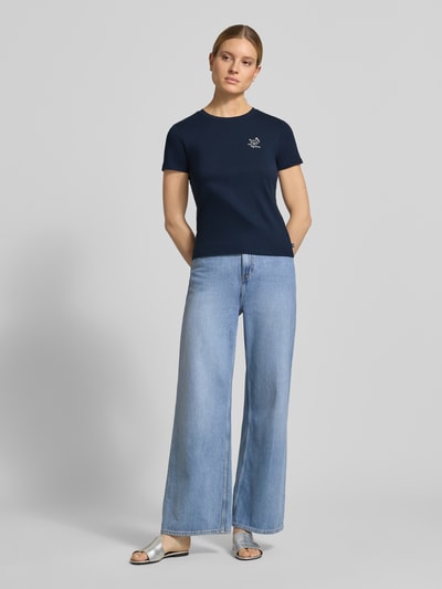 Frauenmodel trägt Regular Fit T-Shirt aus reiner Baumwolle von Tom Tailor Denim in Dunkelblau, unifarben, kurzarm, Rundhals, Jersey, mit Statement-Stitching, kombiniert mit heller Jeans; Ganzkörperansicht von vorne.