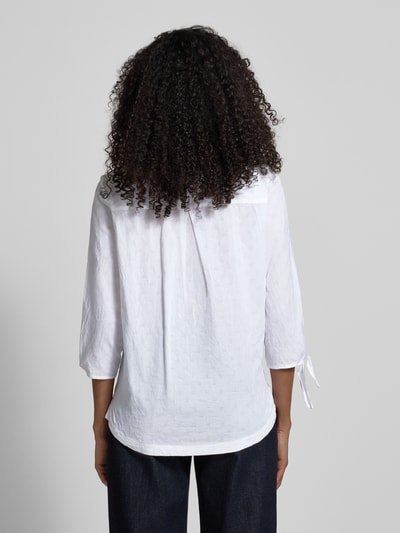 Frauenmodel trägt Regular Fit Bluse mit Tunika-Ausschnitt von Christian Berg Woman aus reiner Baumwolle, weiße Farbe, 3/4-Arm mit Tunnelzug, Rückenlänge 65 cm, Ganzkörperansicht Rückansicht.