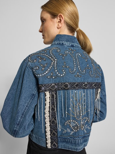 Frauenmodel trägt Jeansjacke mit Perlen Modell 'VISION' von YAS aus reiner Baumwolle, blaue Farbe, Stickereien, Detailaufnahme Rückansicht