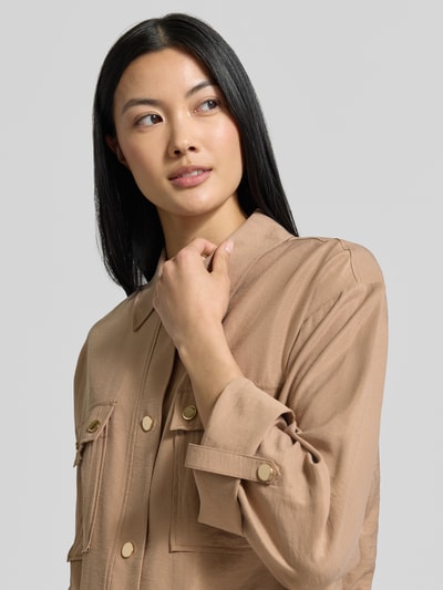 Frauenmodel trägt Regular Fit Blazer mit Brusttaschen von MORE & MORE in Beige, sichtbare Knopfleiste und Umlegekragen, Nahaufnahme Oberkörper, Modal-Mix.