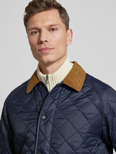 Męski model nosi Regular Fit Steppjacke mit Zweiwege-Reißverschluss Modell 'CITY BEDALE' od Barbour, kolor granatowy, satynowa faktura, kołnierz beżowy, widok z przodu, zbliżenie na górę ciała.