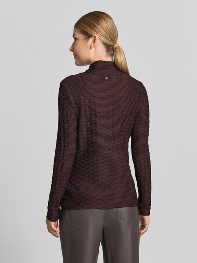 Frauenmodel trägt Skinny Fit Longsleeve aus Viskose-Mix von Marc Cain in Dunkelbraun mit Strukturmuster und Stehkragen, Ganzkörperansicht Rückansicht. Rückenlänge bei Größe 36: 61 cm.