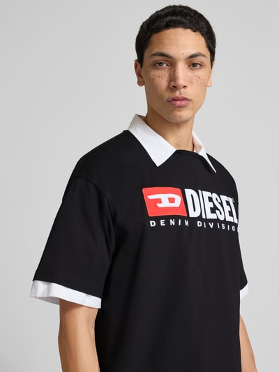 Männermodel trägt T-Shirt mit Label-Detail von Diesel in Schwarz mit weißem Kragen, reine Baumwolle, Regular-Fit, Nahaufnahme Oberkörper.