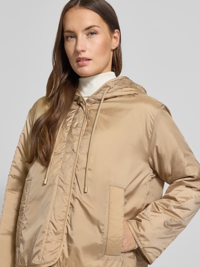Vrouwenmodel draagt Relaxed Fit Functioneel jack met wol-vulling Model 'AGRESTE' van Weekend Max Mara, look: effen, capuchon, drukknoopsluiting, logopatch, lange mouw, waterafstotend, zij-steekzakken, detailopname bovenlichaam.