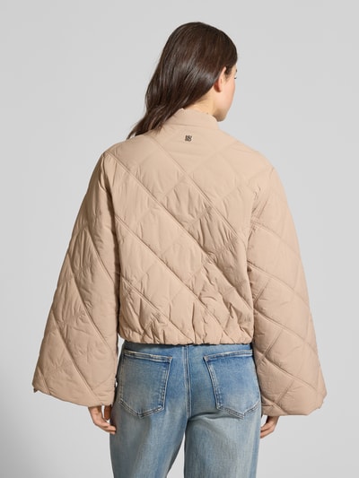 Frauenmodel trägt Relaxed Fit Steppjacke mit Druckknöpfen Modell 'FASTEPPA' von HUGO, beige, uni, wasserabweisend, Rückansicht.