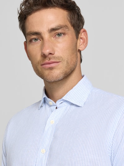 Männermodel trägt Regular Fit Business-Hemd aus Leinen-Baumwoll-Mix Modell 'ROMA' von FIL NOIR in Hellblau mit feiner Streifenstruktur, Nahaufnahme Oberkörper, Haifischkragen und Knopfleiste sind sichtbar.