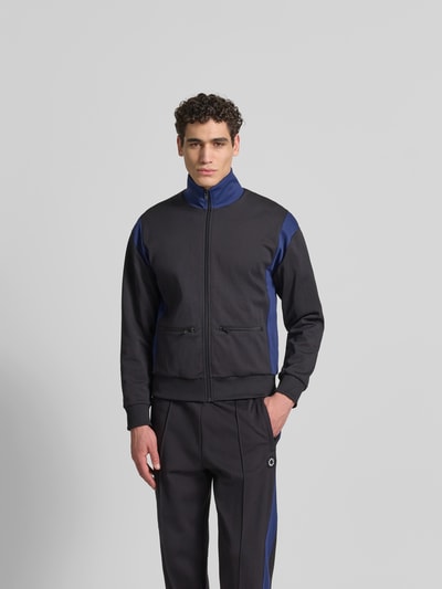 Männermodel trägt Regular Fit Sweatjacke mit Stehkragen von Kenzo in Schwarz und Blau, mit Reißverschluss, Eingrifftaschen, elastische Abschlüsse, Rückenlänge 67 cm, Schulterbreite 51 cm, Ärmellänge 61 cm, Ganzkörperansicht von vorne