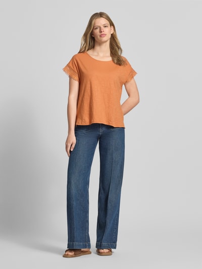 Frauenmodel trägt Regular Fit T-Shirt aus reiner Baumwolle Modell 'NAIN' von Pepe Jeans in Optik: Unifarben, Label-Stitching-Applikation, U-Boot-Ausschnitt, Kurzarm mit Fransen, Materialverarbeitung: Jersey, Ganzkörperansicht von vorne.