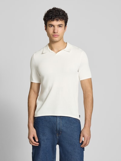 Männermodel trägt Slim Fit Poloshirt mit Strukturmuster von REVIEW, weiße Baumwolle, V-Ausschnitt, Ganzkörperansicht von vorne.