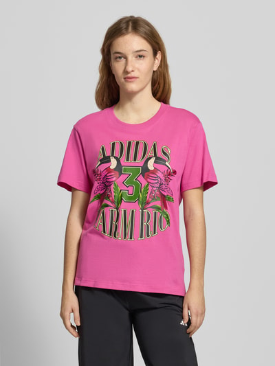 Vrouwenmodel draagt T-Shirt mit Label-Print van adidas Sportswear, roze katoen, regular fit, ronde hals, labelprint; vooraanzicht bovenlichaam.