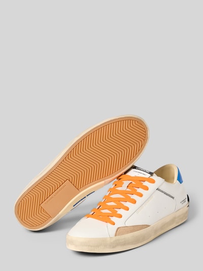 Produktfoto, Sneaker mit Schnürung Modell 'DISTRESSED' von Crime London in Weiß mit orangen Schnürsenkeln, Label-Details, Distressed-Look, abgerundete Spitze, Absatzhöhe 4 cm, Schafthöhe 5 cm, Schaftweite 6 cm.