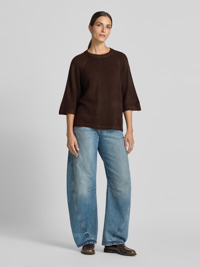 Vrouwenmodel draagt Loose-Fit Pullover met 3/4-mouw van Soyaconcept in donkerbruin met lichte jeans, full-body vooraanzicht.