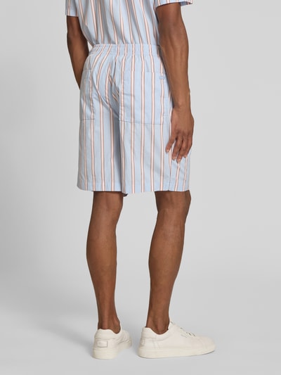 Męski model nosi Relaxed Fit Sweatshorts aus reiner Baumwolle od Lacoste, niebieskie z wielokolorowym wzorem w paski, elastyczny pas ze sznurkiem, kieszenie boczne i tylna, materiał popelina z czystej bawełny, aplikacja logo, widok całej sylwetki z tyłu.