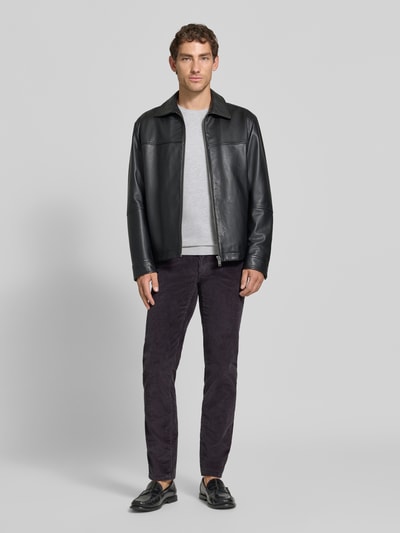 Männermodel trägt eine dunkelgraue Straight Fit Cordhose aus Baumwoll-Mix Modell 'Mythos Flex Cord' von Brax, kombiniert mit hellgrauem Shirt und schwarzer Lederjacke, glatte und strukturierte Oberflächen, Ganzkörperansicht von vorne, Herren Cordhose von Brax.