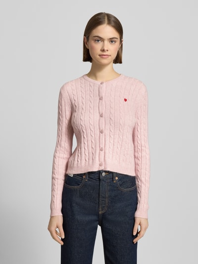 Frauenmodel trägt Shaped Fit Cardigan aus Viskose-Mix Modell 'KATIA' von Only, Optik: Unifarben in Strickoptik mit Zopfmuster und Label Stitching, Rundhals, einreihige Knopfleiste, Langarm, gerippte Abschlüsse, Materialverarbeitung: Strick, Ganzkörperansicht von vorne.