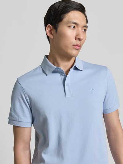 Männermodel trägt Modern Fit Poloshirt mit Logo-Stitching Modell 'Primo' von JOOP! Collection aus reiner Baumwolle, Nahaufnahme Oberkörper.