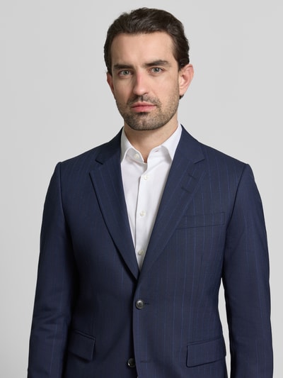 Männermodel trägt Regular Fit Anzugjacke aus Woll-Mix Modell 'Justin' von Tiger Of Sweden, dunkelblau mit feinen Streifen, Nahaufnahme Oberkörper.