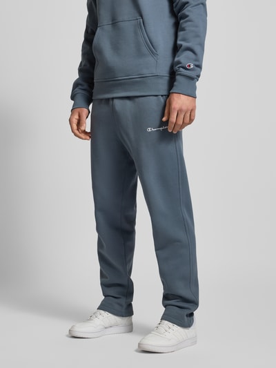 Mężczyzna nosi Straight Fit Sweatpants mit Label-Stitching od CHAMPION z mieszanki bawełny, elastyczny pas, wyhaftowane logo, widok z przodu do kolan.