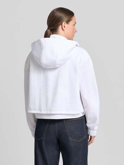 Frauenmodel trägt Jacke mit Stehkragen und verdecktem Reißverschluss von monari, weiß, strukturierte Oberfläche, Reißverschlusstaschen, Regular-Fit, Rückenlänge 49 cm, Schulterbreite 55 cm, Brustweite 57 cm, Ärmellänge 58 cm, Ganzkörperansicht Rückansicht.
