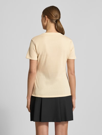 Frauenmodel trägt Regular Fit T-Shirt aus Viskose-Mix von LIU JO SPORT, cremefarben mit Glitzer-Optik und Logo-Detail, Rückenlänge 60 cm, Ganzkörperansicht Rückansicht.