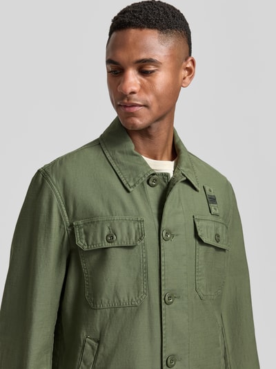 Männermodel trägt Regular Fit Hemdjacke mit Brusttaschen Modell 'Goodale' von Blauer Usa in Olivgrün, reine Baumwolle, Nahaufnahme Oberkörper.