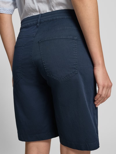 Vrouwenmodel draagt Regular Fit Bermuda uit katoenmix model 'MAINE B' van Brax, effen kleuren, 5-pocketmodel, riemlussen, achteraanzicht.
