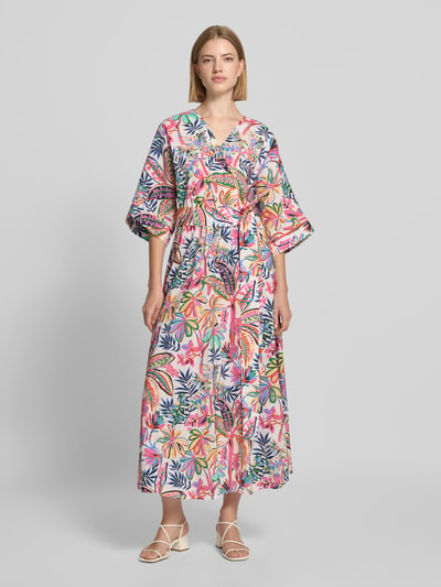 Frauenmodel trägt Midikleid aus Viskose-Mix mit floralem Allover-Print von Milano Italy, bunte Blütenmuster, Taillenband, Ganzkörperansicht von vorne.