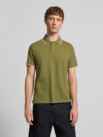 Męski model nosi Regular Fit Koszulka polo z wyhaftowanym logo Model 'Hedin' od Blend z bawełny, oliwkowy kolor, krótkie rękawy, Ganzkörperansicht von vorne.